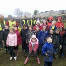 Local school children help with planting new trees at Carbarns Woodland